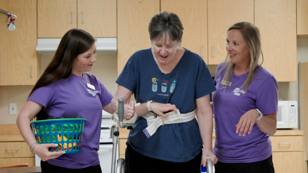 A woman and two nurses work in therapy for short term rehab at Care Manor
