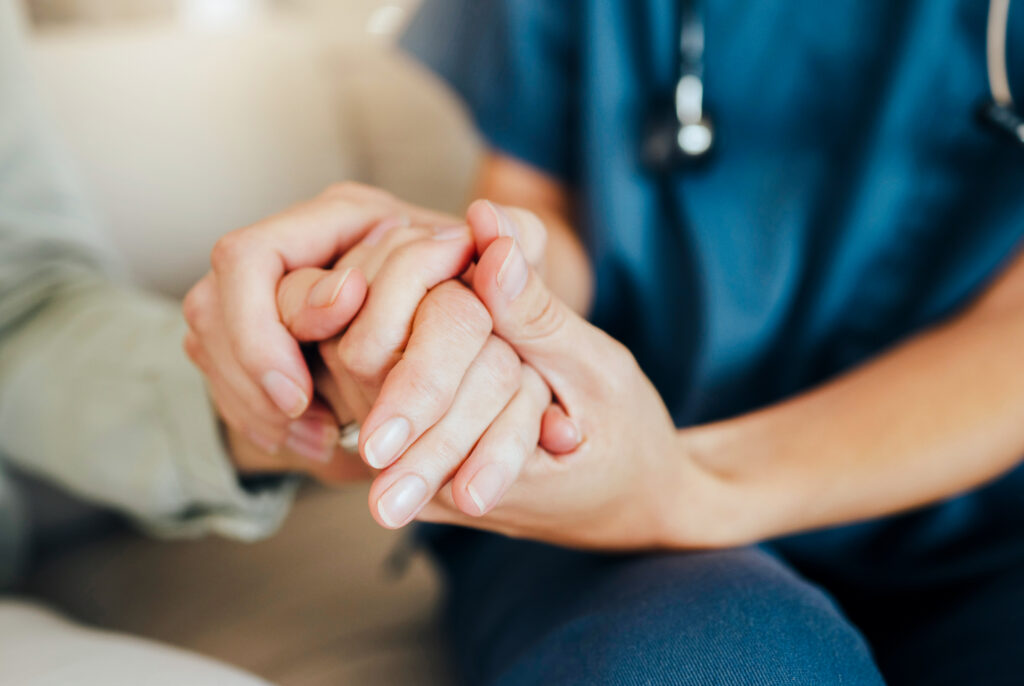 A nurse and resident holding hands at a skilled nursing facility nursing home